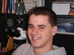 Michael Snider next to microscope in grad lab